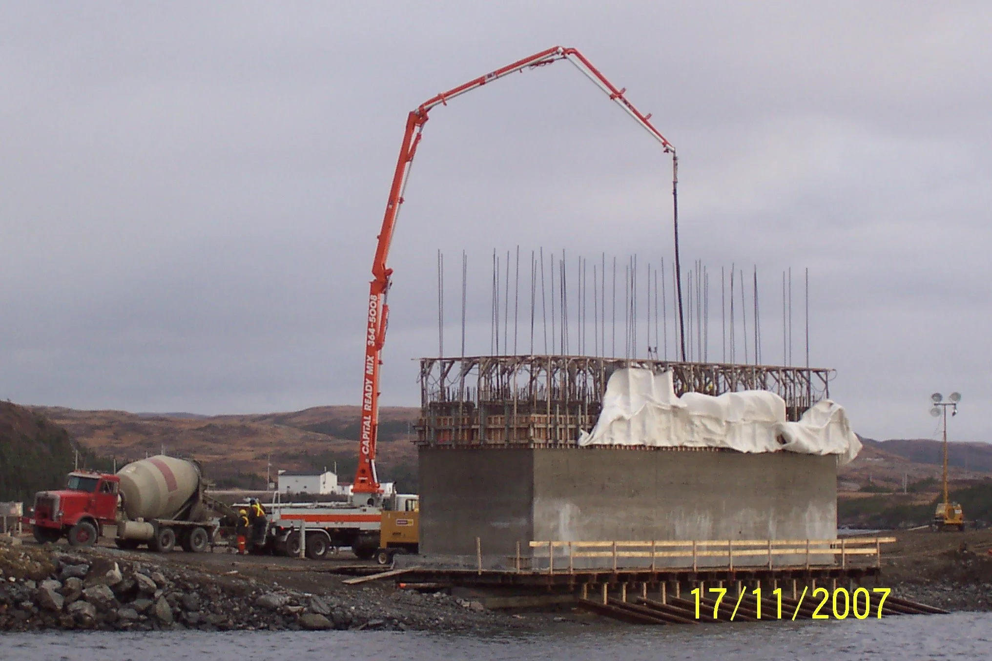 A crane working on the new concrete caisson wharf in Port Aux Basques, circa 2007. The new wharf was constructed on land, and launched via slip table, and sunk into position.
