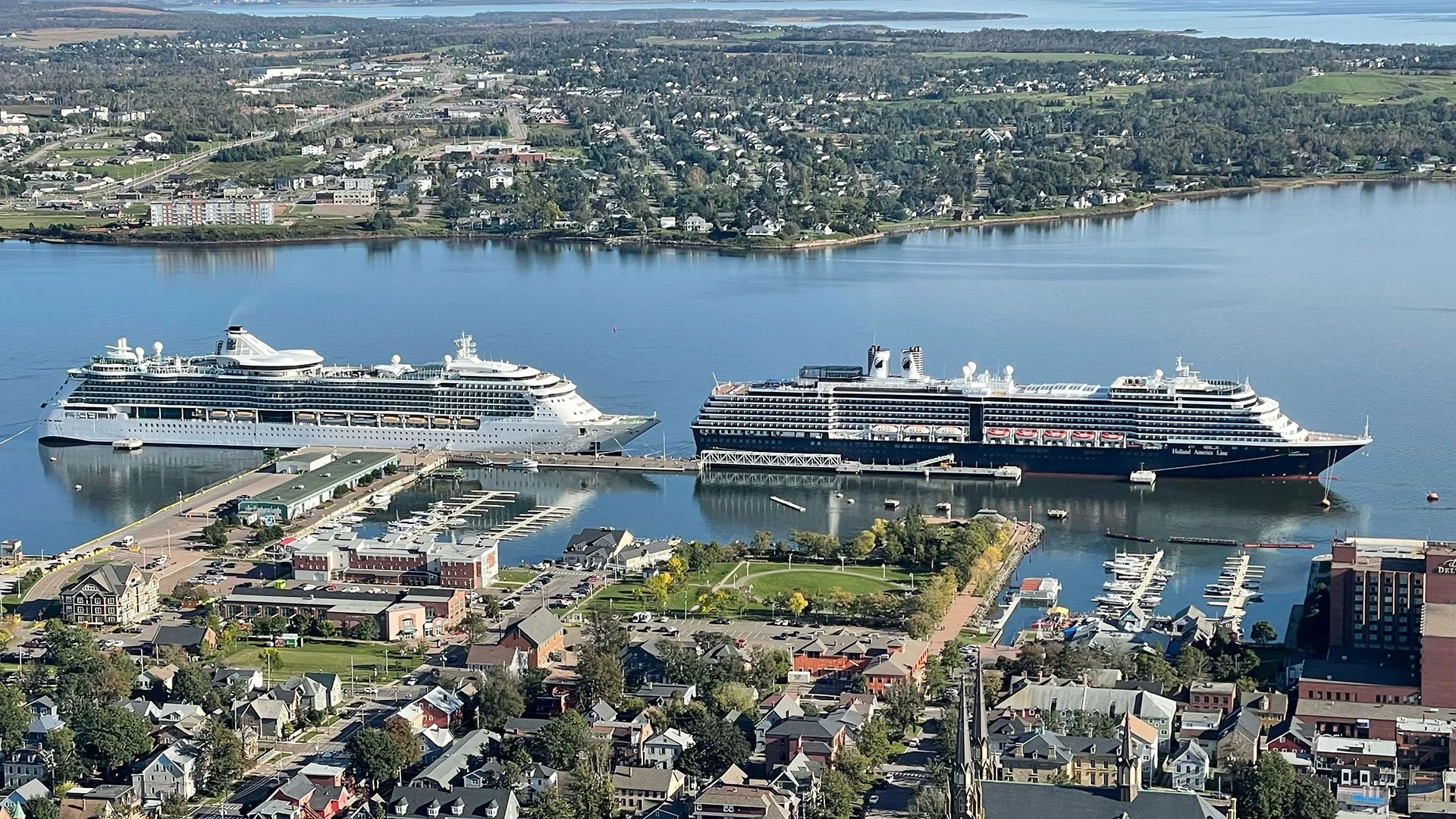 An image captured via drone of the completed Charlottetown cruise ship terminal expansion, and two of the first vessels to arrive. In the foreground and background, Charlottetown can be seen wrapping the harbour.