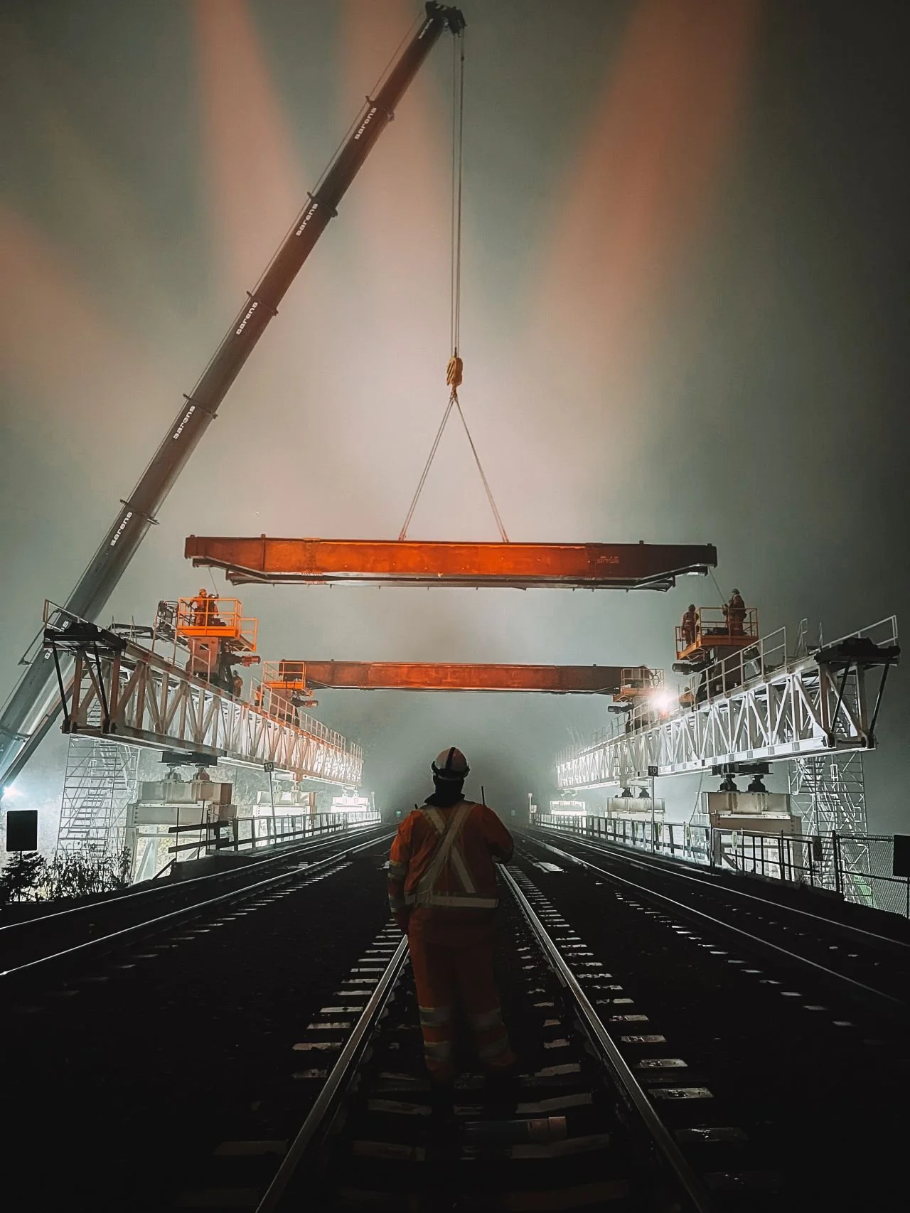 A crane lifts the gantry's header beam into position. Image originally shared by Metrolinx via their LinkedIn profile.