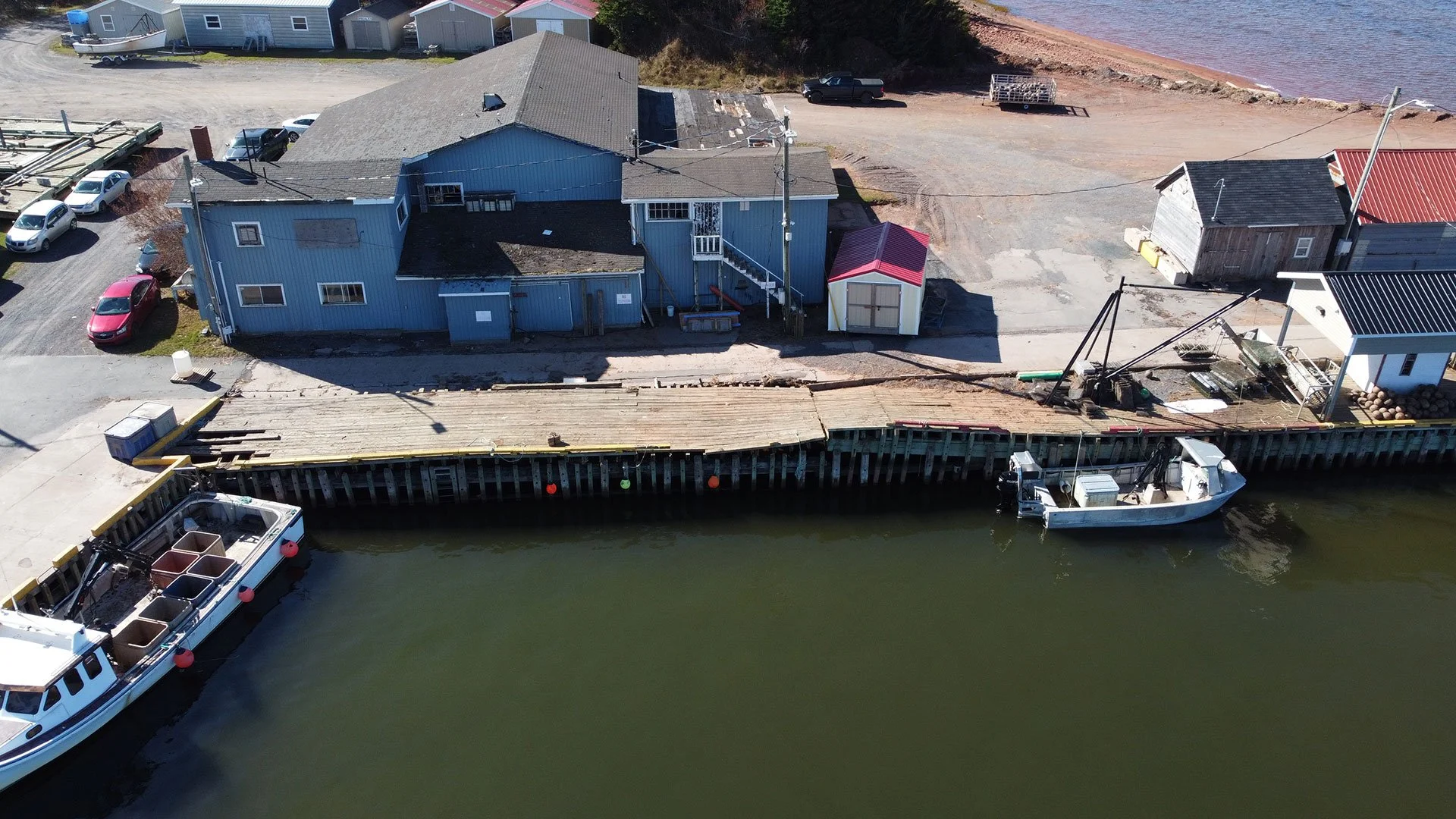 An aerial view of structures damaged at Red Head Harbour during Hurricane Fiona in 2022.Significant surface area was rendered unusable due to extensive deck loss.