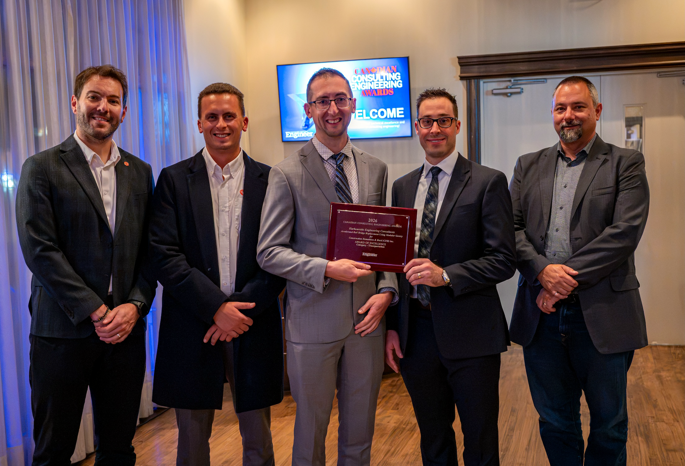 The engineering team behind the Etobicoke Rail Bridge Gantry during the 2026 CCE Awards Gala. Wade Pottie and Calvin MacAulay from Harbourside Engineering are front and centre with the award plaque in hand.