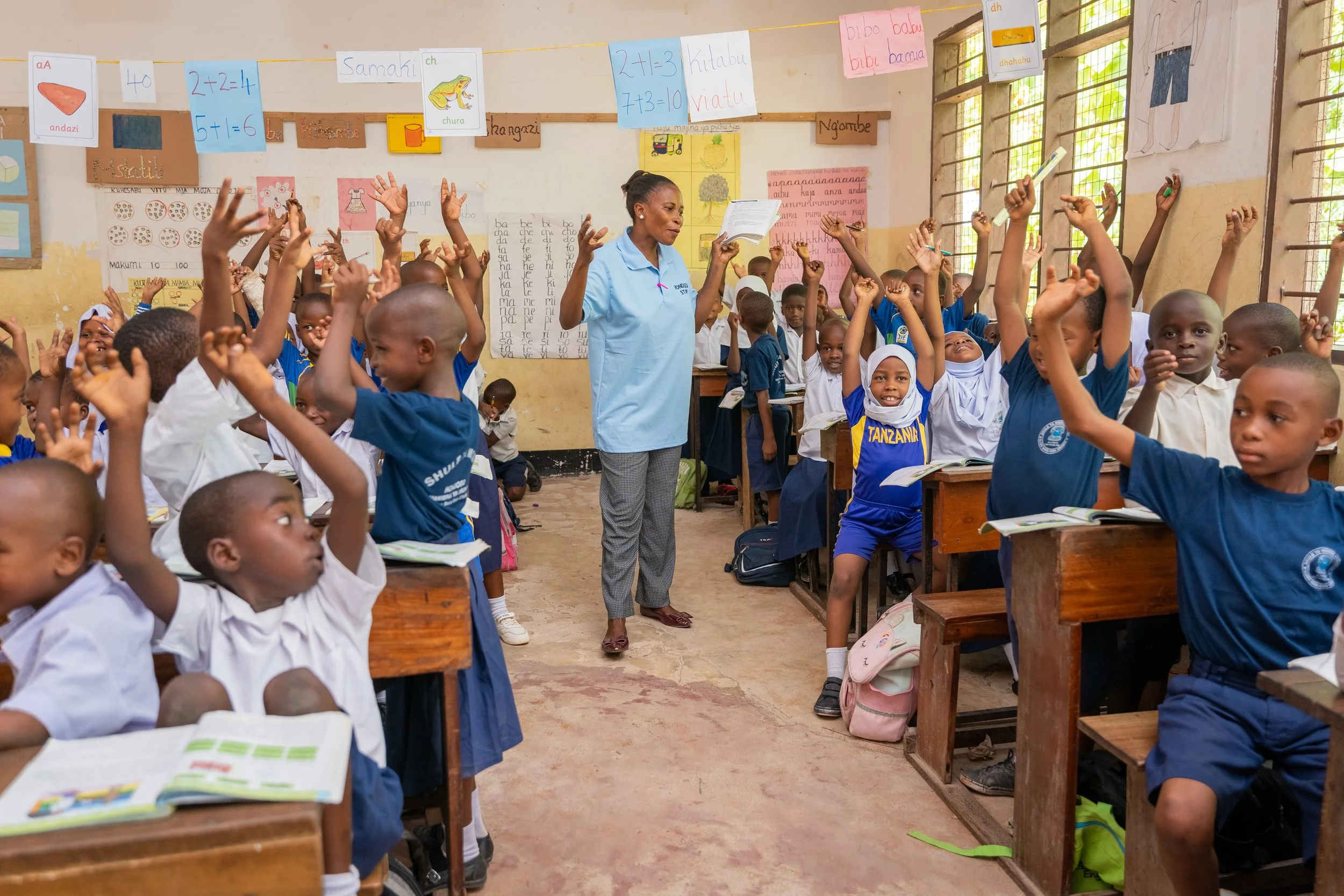 Teacher and primary students in Tanzania actively engaged in classroom