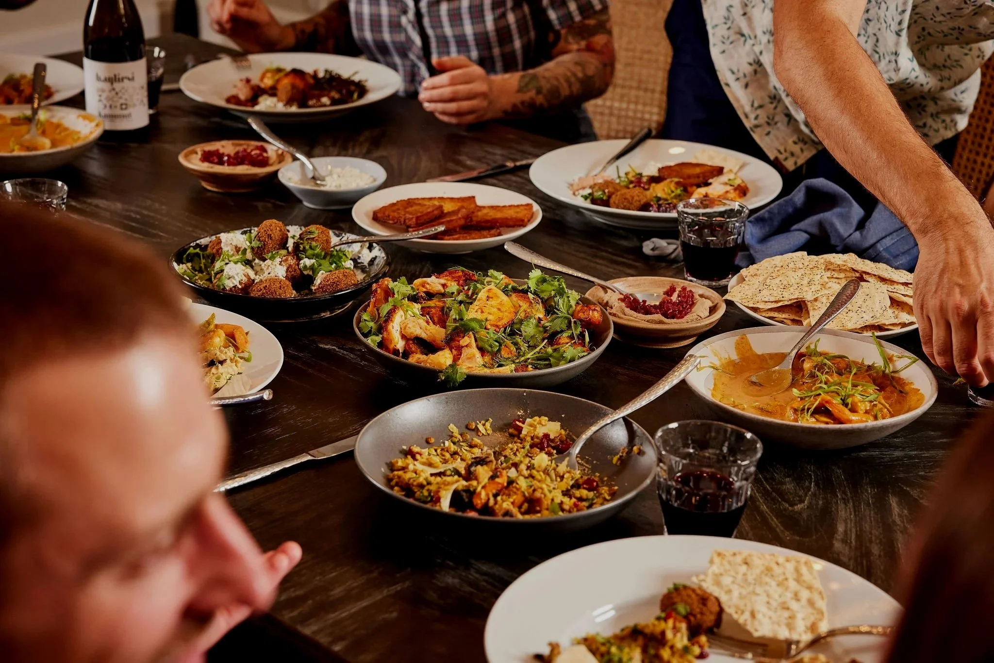 A group of six DanDan staff members standing and sitting outside the restaurant with a red sign that says "dandan."