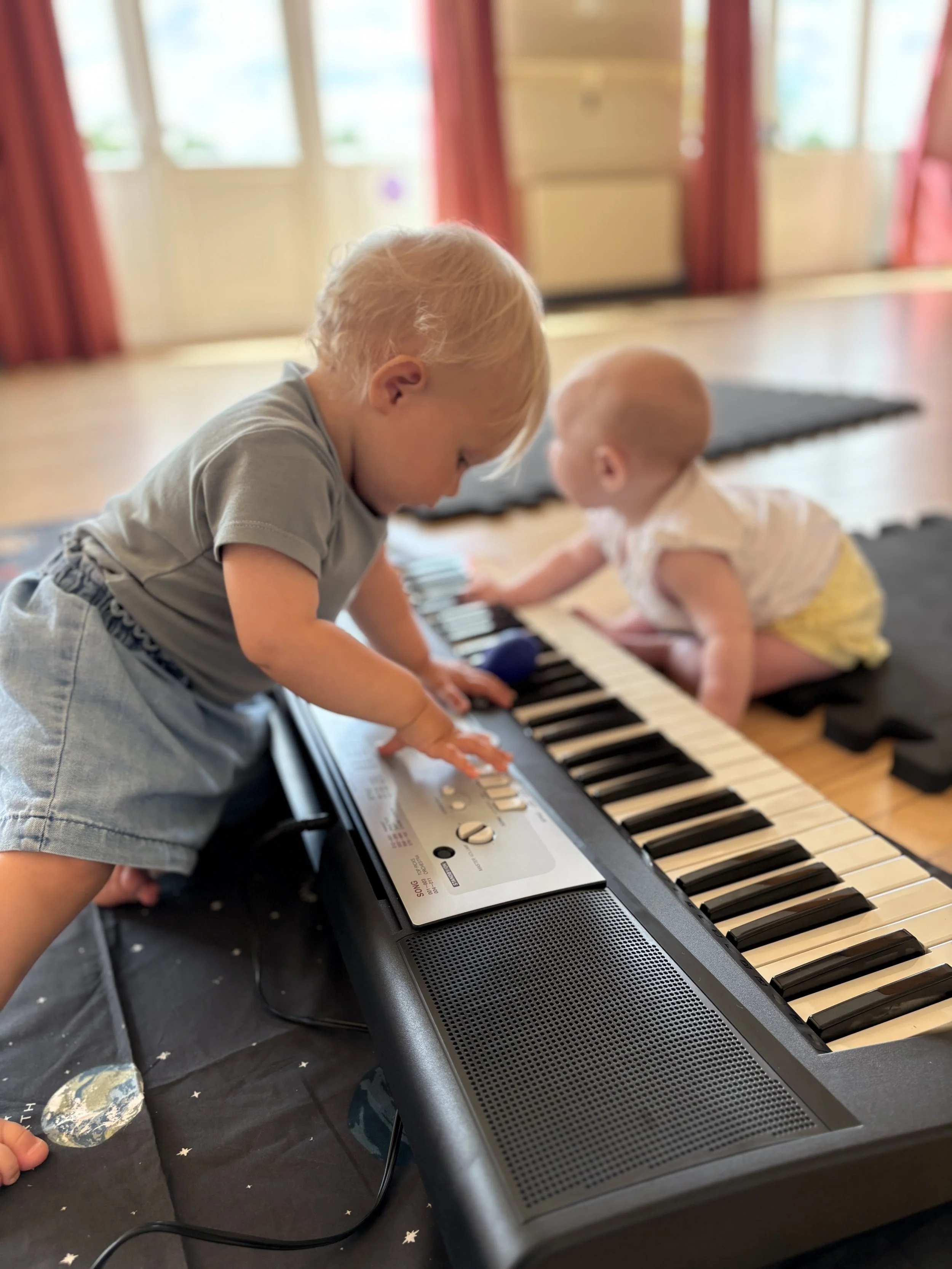 Toddler and baby playing keyboard at Mini Musicians baby music class Alfold, Surrey