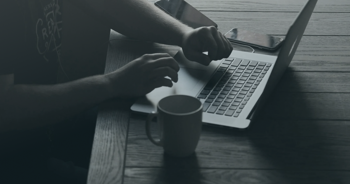 Person typing on a laptop with coffee, booking a free call with a Squarespace web designer