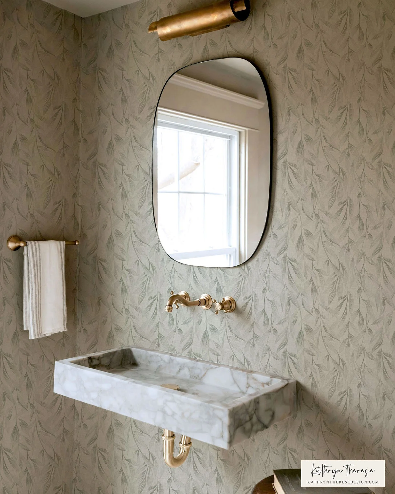 Japandi style wallpaper featuring a distressed, drop botanical style in a powder room with rustic fixtures and a marble sink.