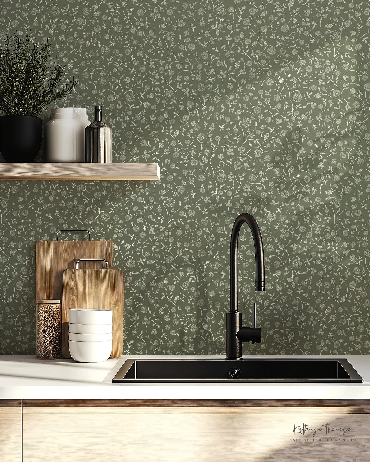 Kitchen countertop with black sink, black faucet, white countertop, wooden cutting boards, white bowls, a decorative jar, and a shelf with potted plant, white vases, and a metal container, against a green floral-patterned wallpaper background.