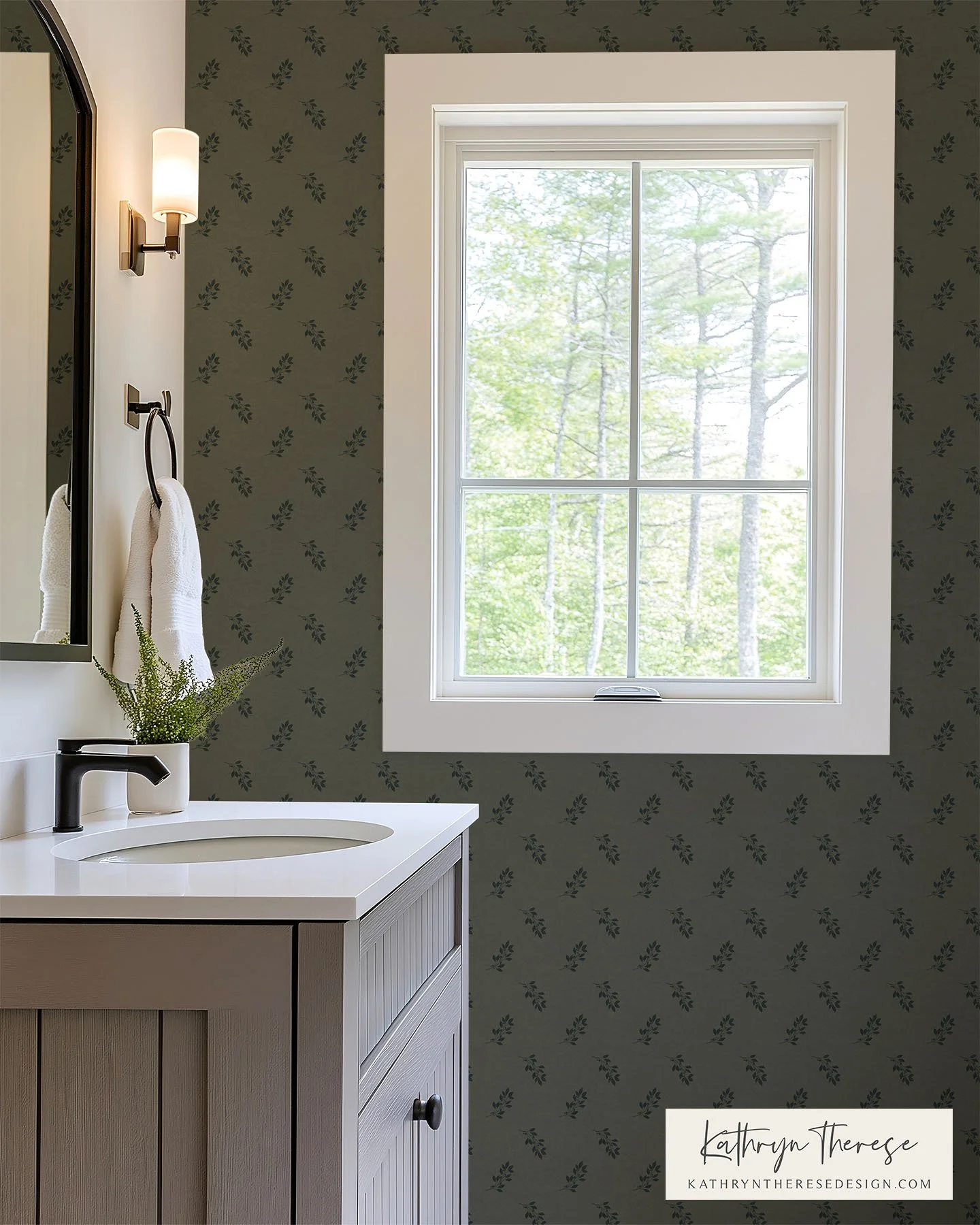 Bathroom with gray vanity, black faucet, white countertop, small plant, white towels, wall-mounted light fixture, window with forest view.
