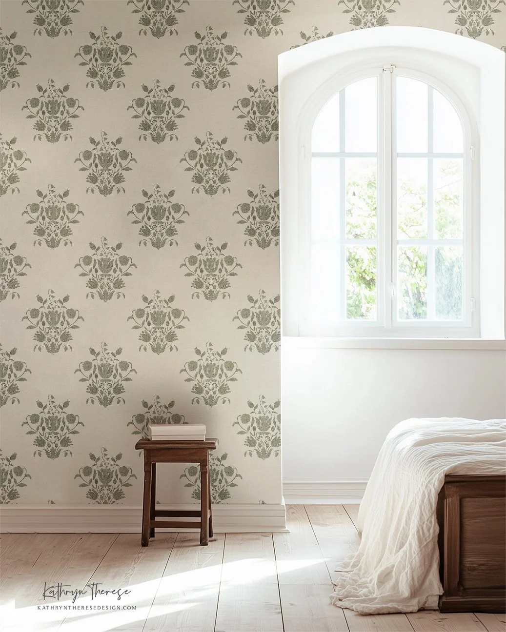 A bedroom with a window, a bed with a white blanket, a small wooden stool with a book, and patterned wallpaper with floral motifs.