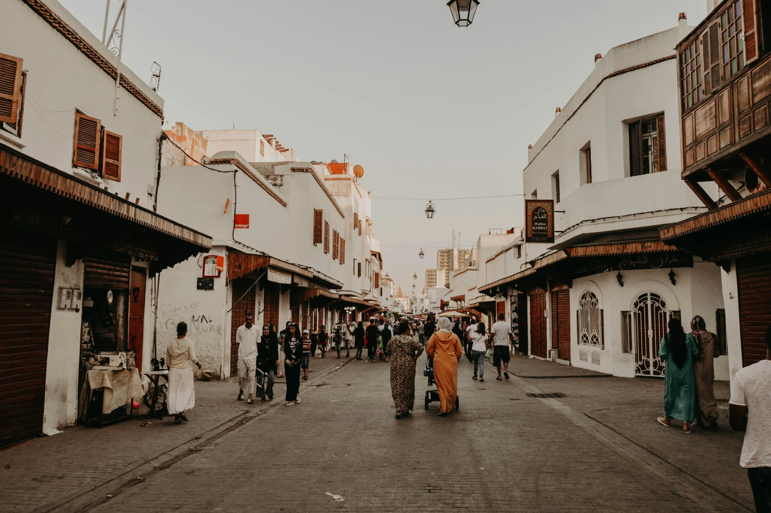 Rue piétonne avec des bâtiments blancs et des personnes qui marchent