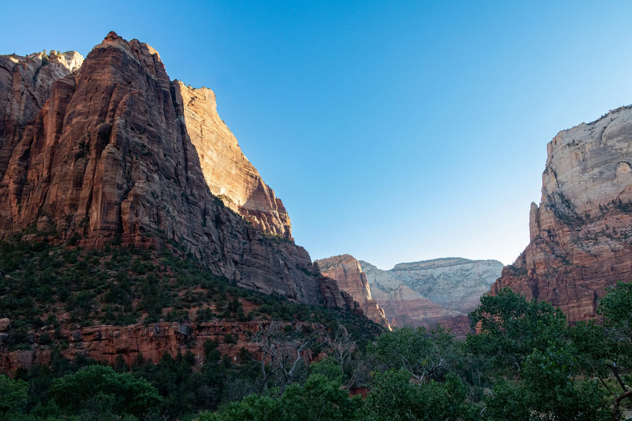 Canyon avec des falaises rocheuses colorées sous un ciel clair