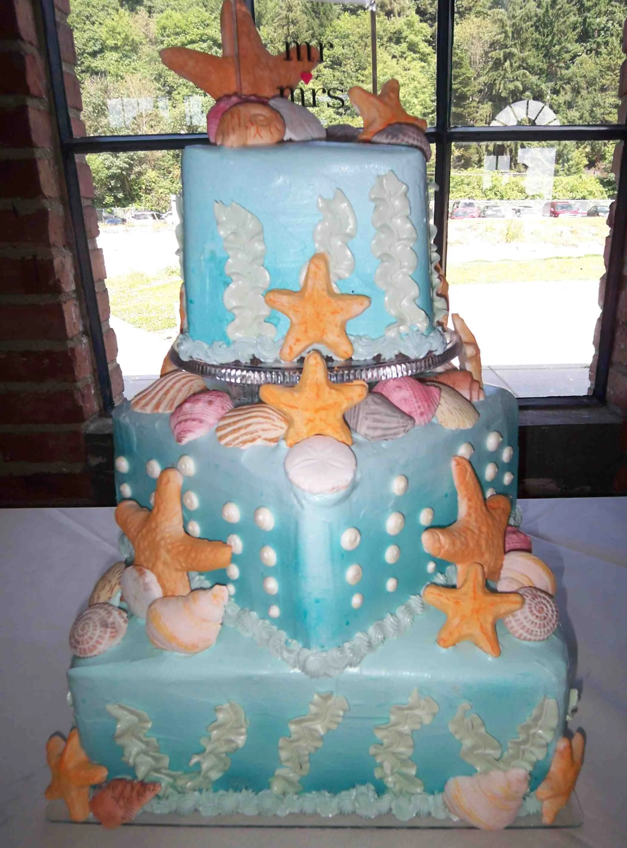 Under The Sea Diagonally Stacked Color Oversprayed Buttercream Cakes Sugar Porcelain Seashells and Starfish Piped Bubbles and Underwater Vegetation