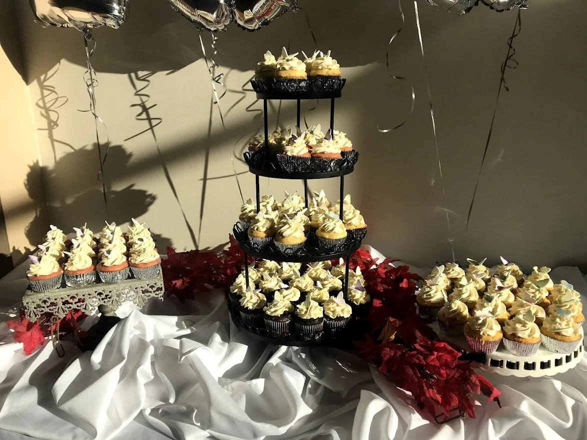 Cupcake Celebration Tower Sugar Butterflies Attachments Two single level cake stand  with cupcakes Bunched white linen on table Red silk Poinsettias