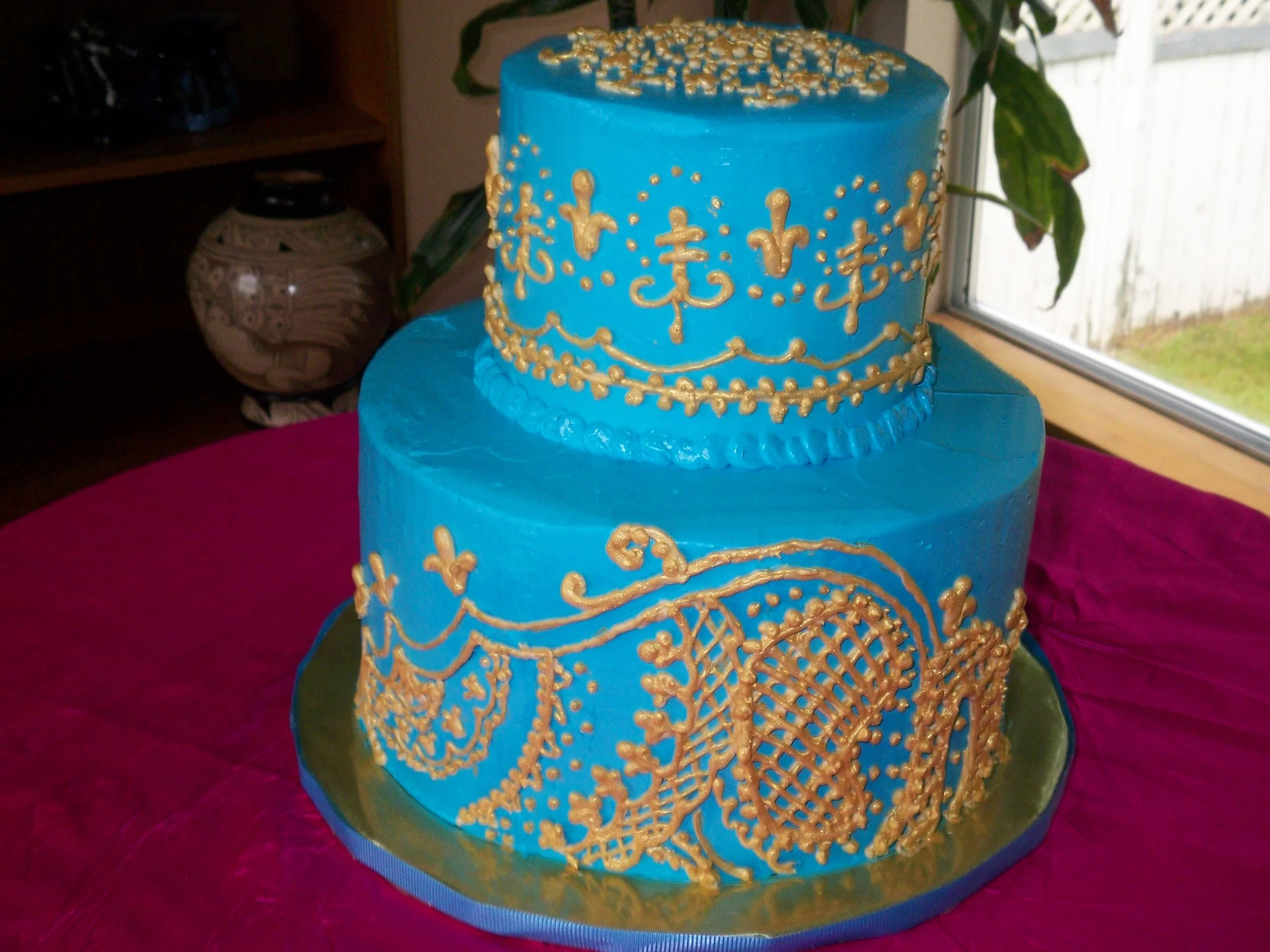 Wedding Shower Indian Design Two Stacked Tiers Turquoise Buttercream Frosted Cake with Gold Applique Simulating  Dress Design Siting on Gold Base with Blue Ribbon Edging