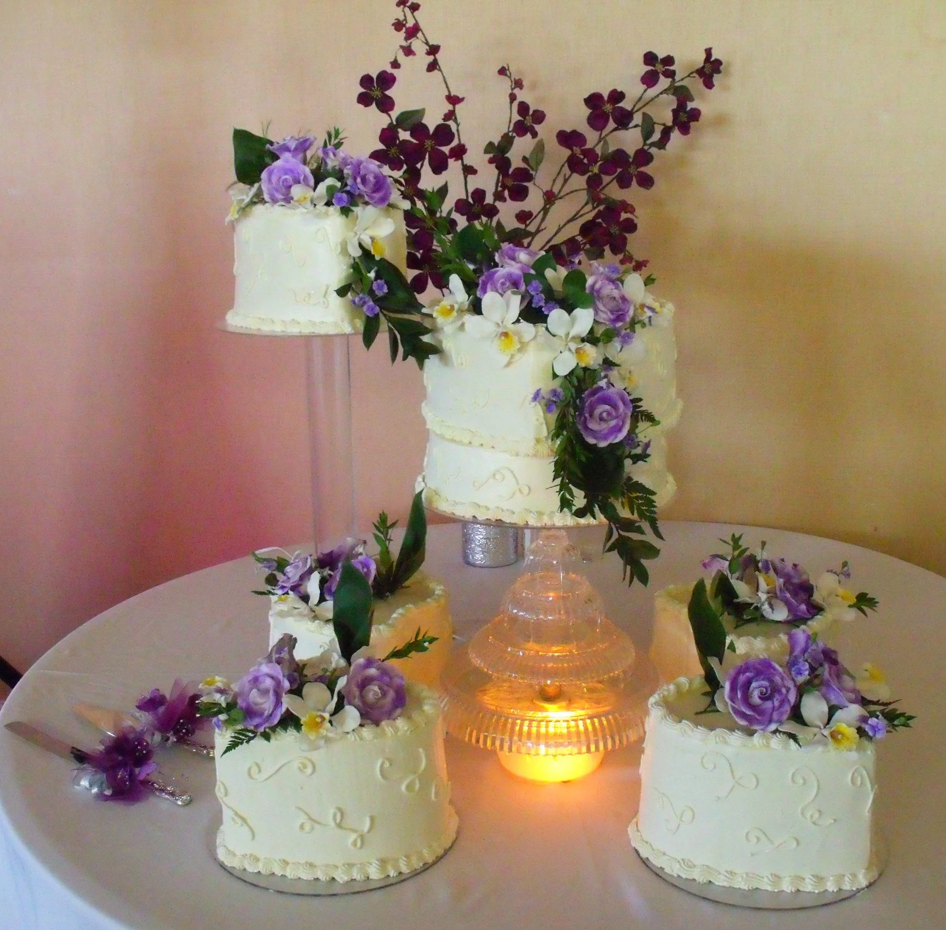 Wedding Cake with Individually Separated Heart Shaped Tiers on Crystal Plates and Towers Blended Fresh and Sugar Porcelain Sugar Dusted Full Open Roses and Orchids with Fresh Greens Lighted Fountain Centerpiece