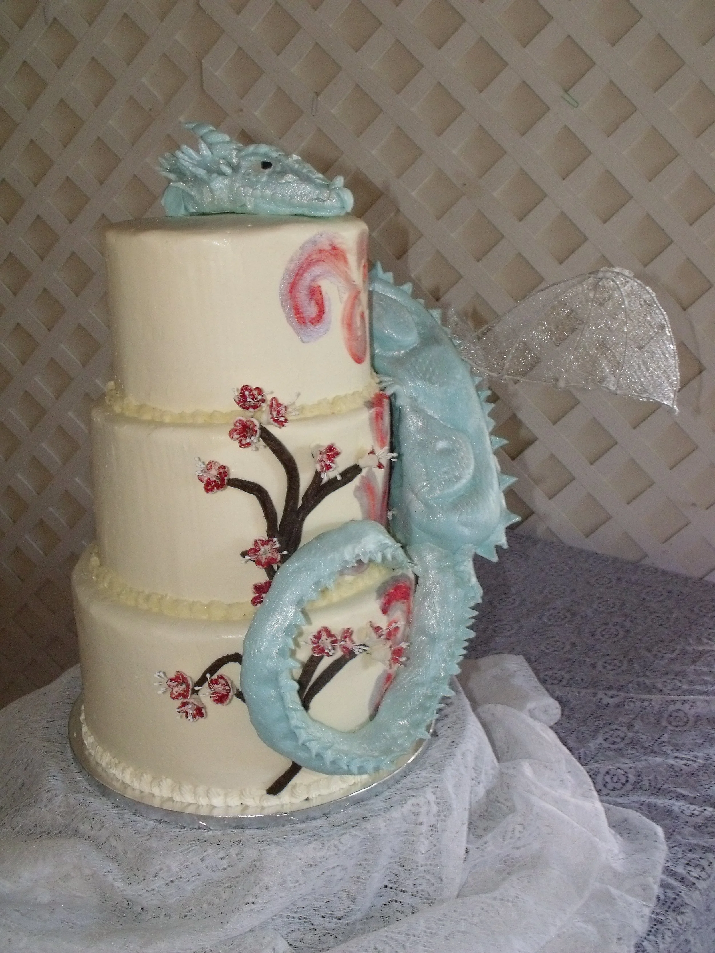 Wedding Cake Three Tier stacked buttercream cake chocolate cherry tree sugar Porcelain cherry blossoms Sculpted fondant dragon clinging to cake side with dragon head on top gossamer wings  