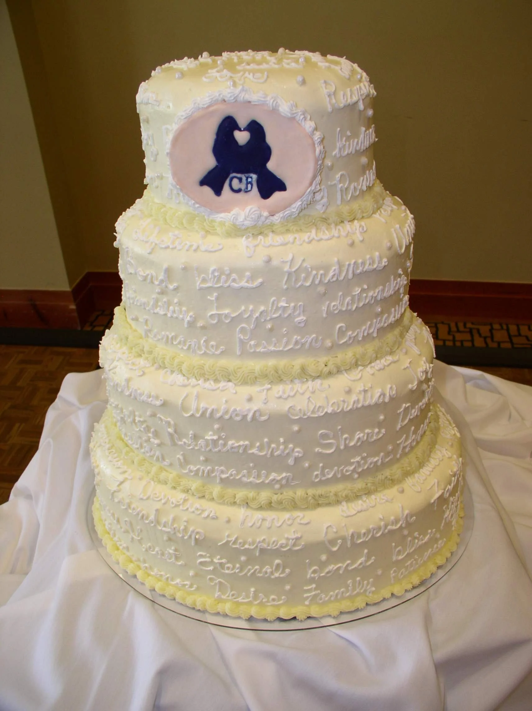 Wedding Cake Four Oval Stacked Tiers Featuring Vows Written in Buttercream with Floated Sugar Color Flow  Emblem Replicating Wedding Invitation Design