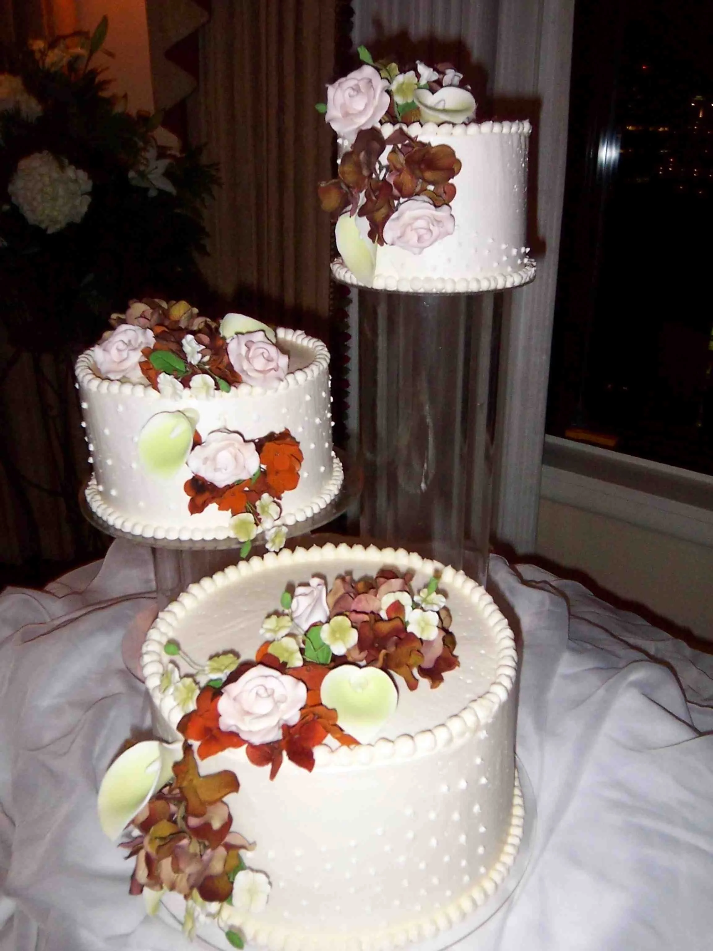 Autumn Splendor Wedding Cake Three Adjacent Crystal Pillar lifted Buttercream Cakes with Piped Buttercream Dot Designs Sugar Porcelain Rose and Lilies Mixed with Silk