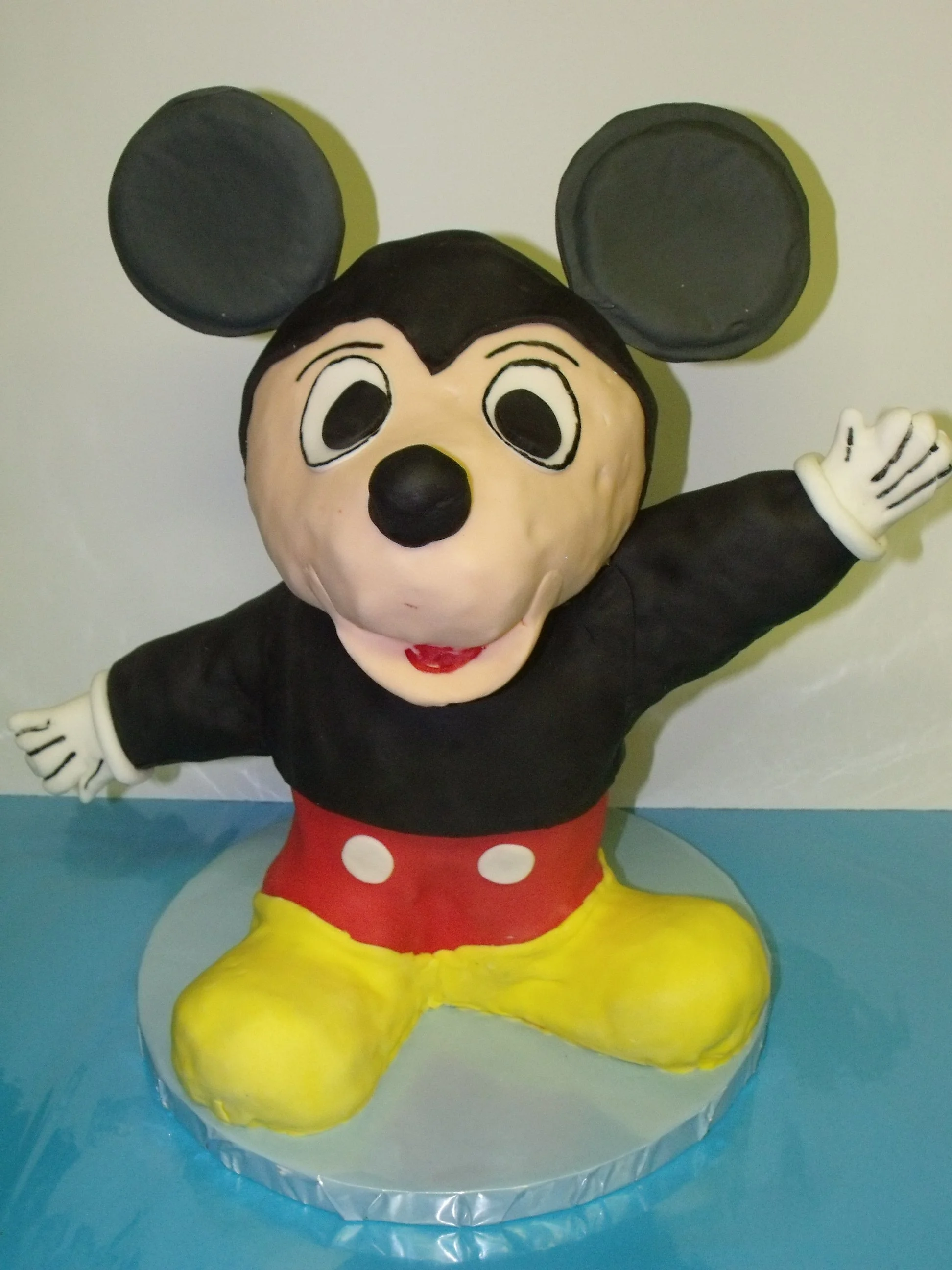 Three Dimensional Two Foot Tall Fondant Covered Sculpted Mickey Cake On Silver Wrapped Board 