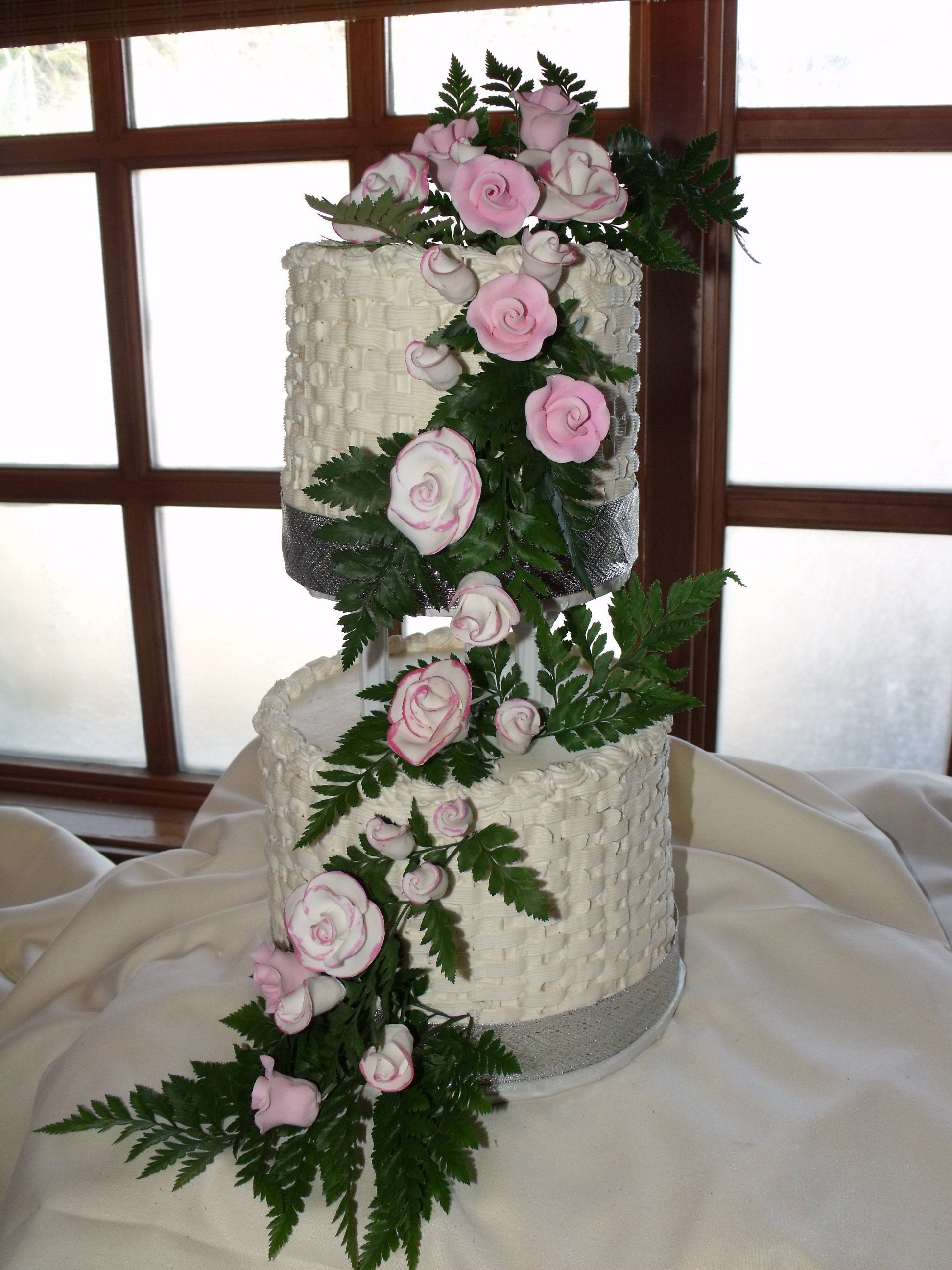 Buttercream Basketweave Decorated   Wedding Cake with Cascade of Sugar Porcelain Roses over Fresh Greens