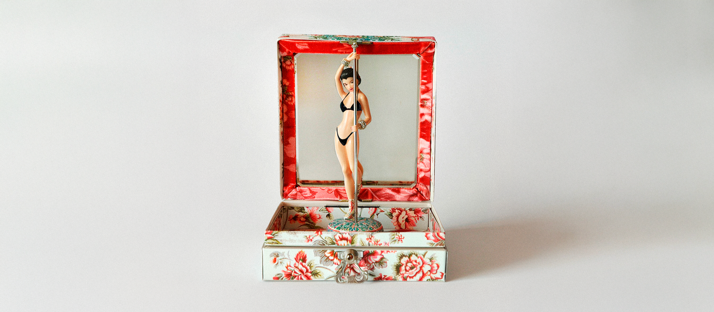 Decorative jewelry box with a mirrored lid, featuring a vintage-style lap dancer figurine inside.
