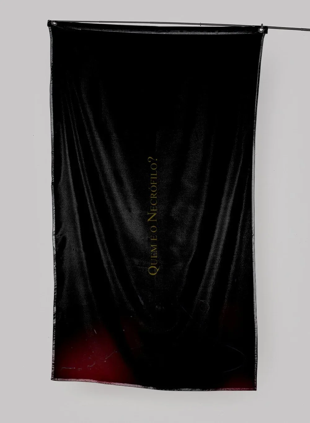 A black banner hanging from a ceiling with the gold text 'Quien neɣró perfil ?' printed vertically in the center.