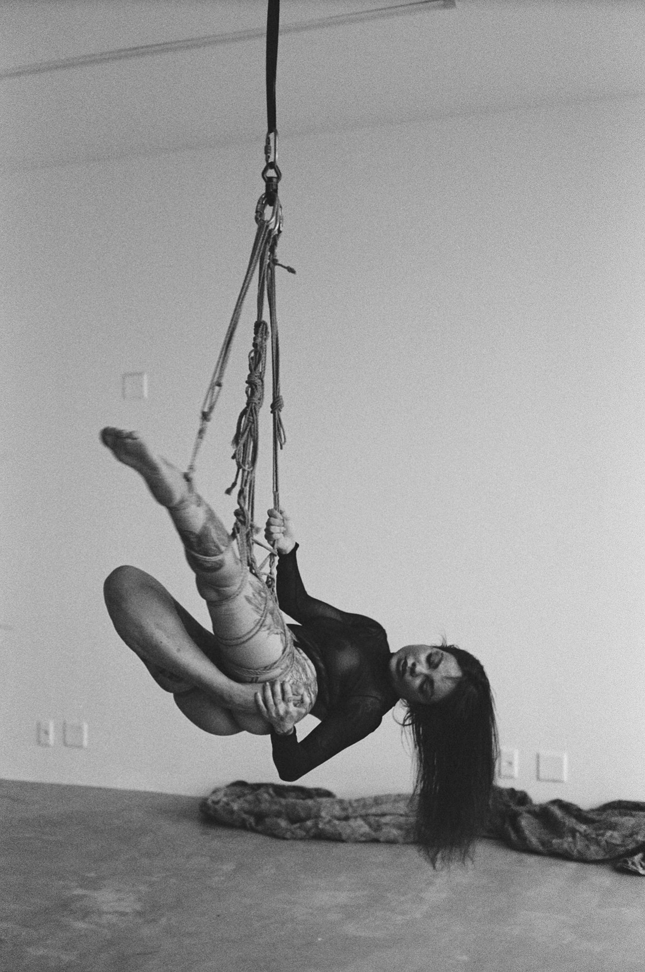 Scenic landscape of a mountain lake with rolling green hills, a calm turquoise lake, and majestic mountains under an overcast sky.