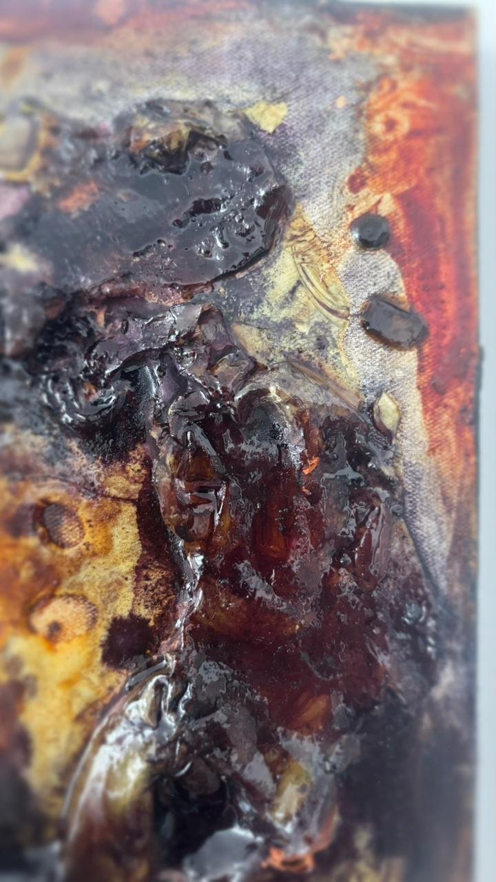 Close-up of a burned, charred object with blackened, melted, and crispy textures.