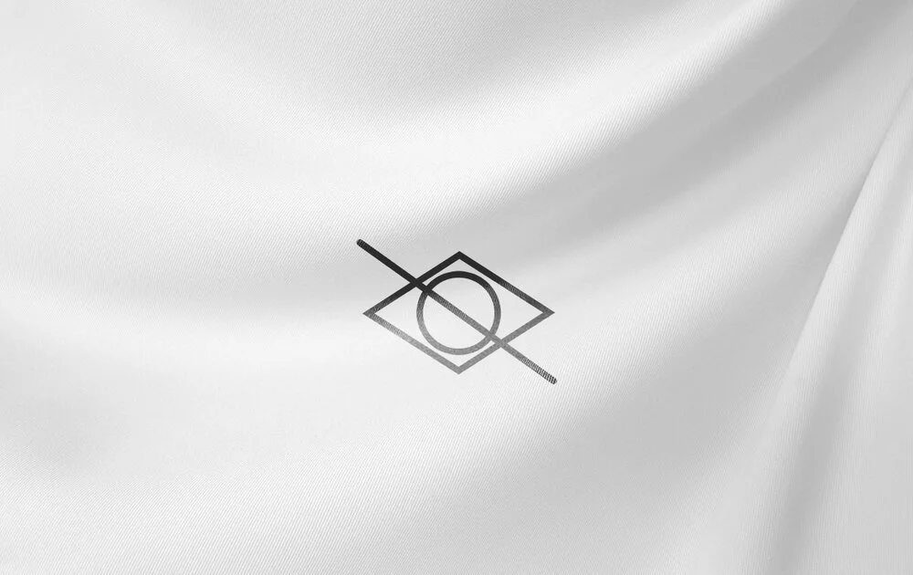 Close-up of a white fabric with a printed laundry care symbol indicating tumble dry on low heat.