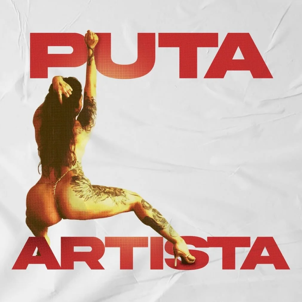 A woman with long hair, sitting on a high heel shoe, revealing tattoos on her back and thigh, with the words 'PUTA ARTISTA' in large red font.
