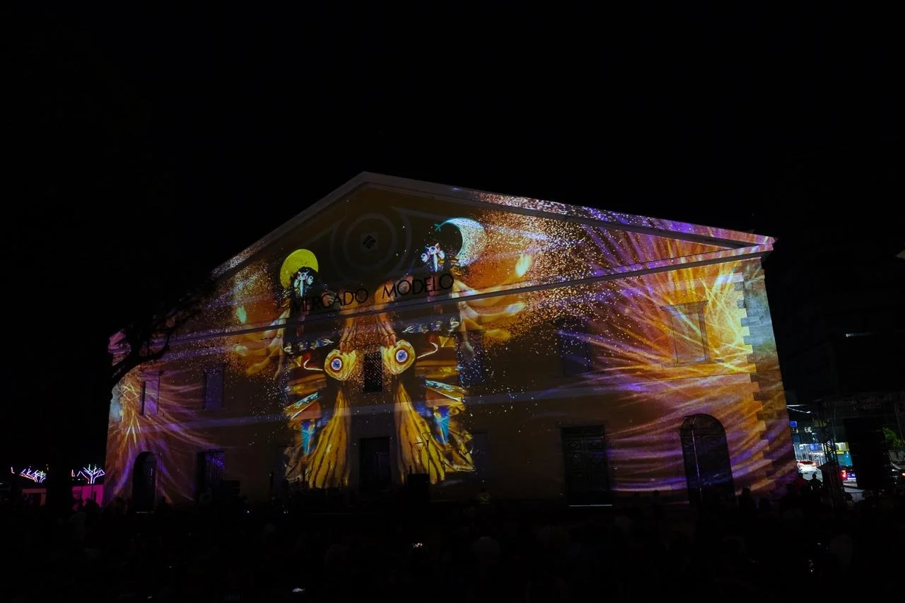 A building with colorful light projections displaying art at night.