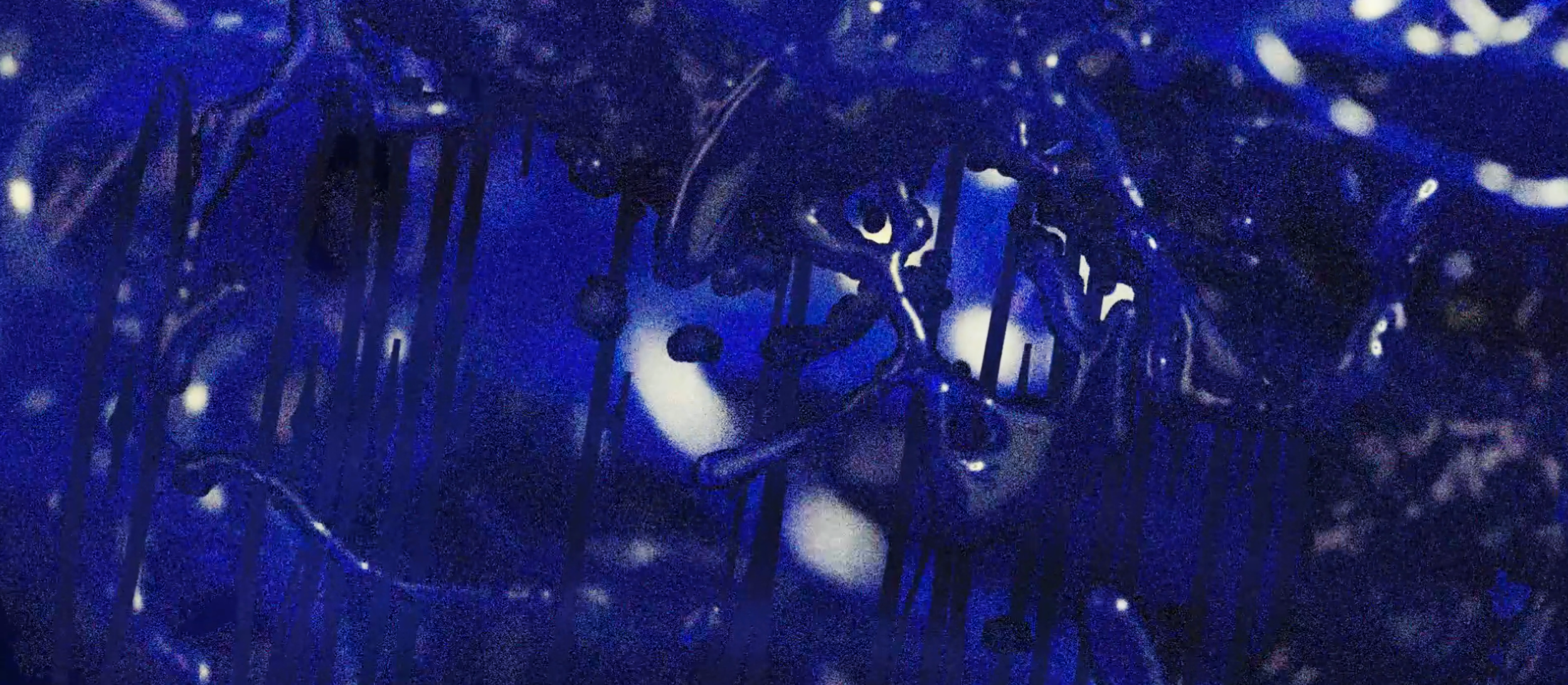 Close-up view of dark, intricate, metallic sculpture or structure illuminated with blue lighting, with an abstract and complex design.