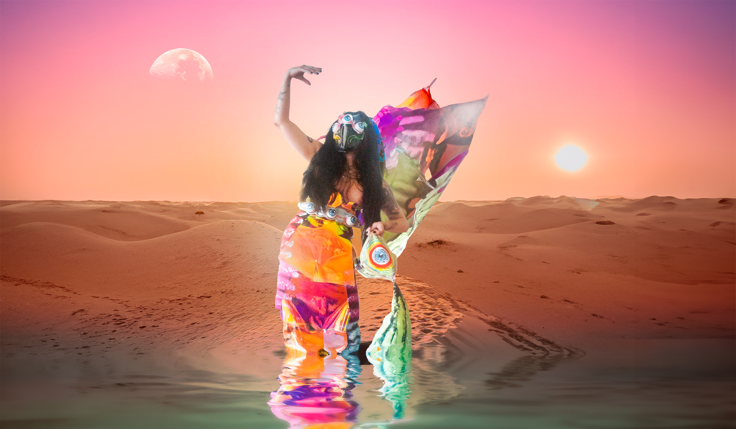 A person dressed in colorful, abstract clothing with eye patterns and a mask is standing in a desert landscape at sunset, with water at their feet, a moon and a sun in the sky.