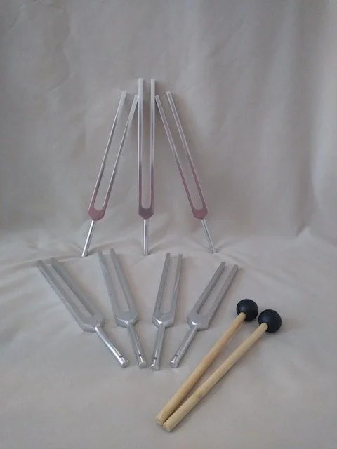 A white orchid flower balanced on a smooth, rounded stone with a neutral beige background.