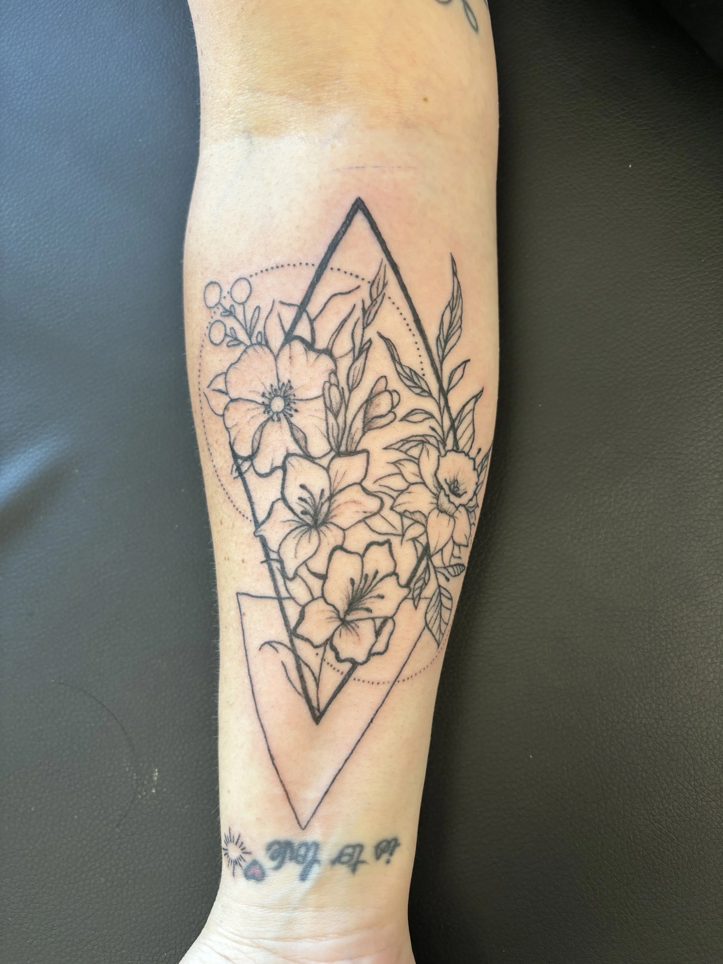 Fine line floral arm tattoo