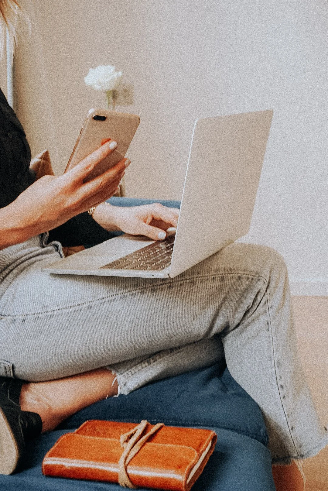 A woman working on her business at home while using her computer and cellphone
