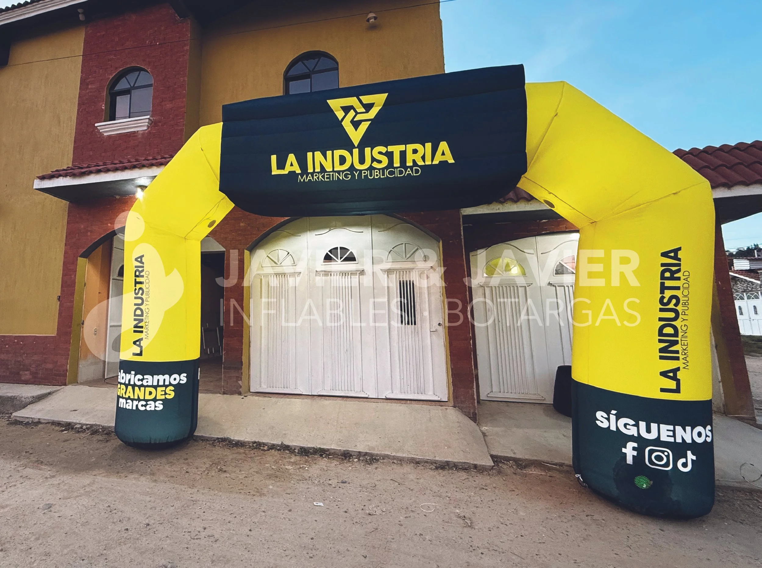 Arco inflable amarillo y negro con señalización de 'La Industria' marketing y publicidad, en la entrada de una casa