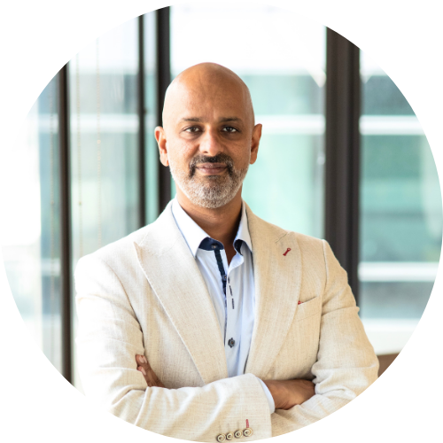 Giridharan Sivaraman wearing a pale suit against a background of windows.