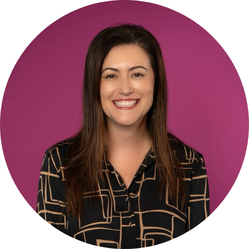 Portrait of Alice Salomon smiling, facing the camera. She has long brown hair and is wearing a black patterned shirt.