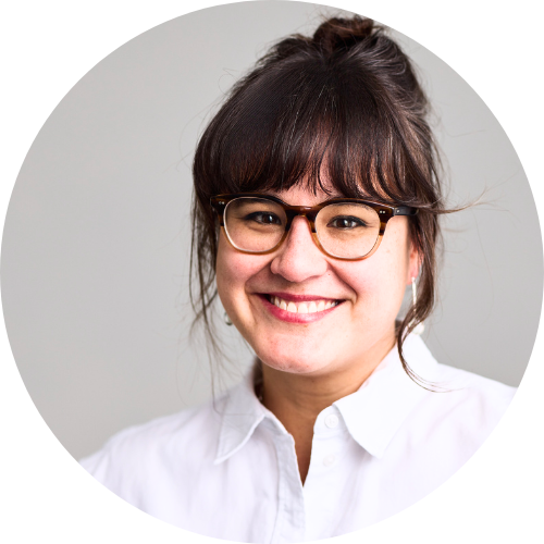 Portrait of Sofia Madden smiling, wearing glasses and a white shirt