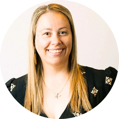 Middle aged woman with light straight brown hair with blonde highlights smiling