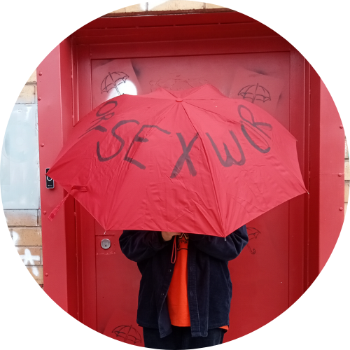 Portrait of Bee Charika holding a red umbrella