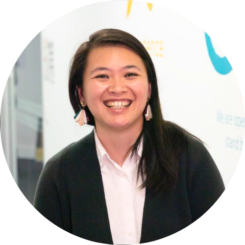 Thuy Linh smiling, facing the camera, wearing a white shirt and black jacket.