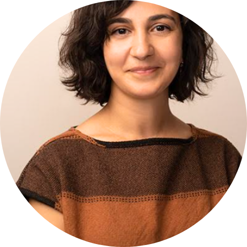 Portrait of Setareh Ghandehari smiling, facing the camera wearing a brown striped shirt