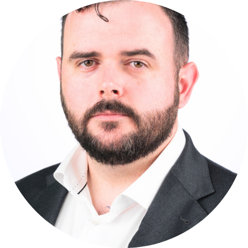 Portrait of Joseph Mitchell facing the camera, wearing a white shirt and black jacket.