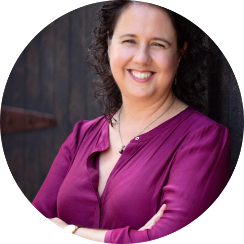 Amanda Cahill smiling, facing the camera, wearing a magenta shirt.
