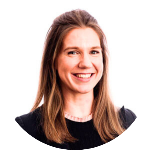 Portrait of Margaret Quixley, a white woman with short brown hair smiling, wearing a black jacket