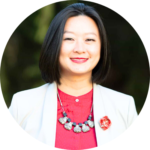 Wesa Chau wearing a red shirt and cream jacket