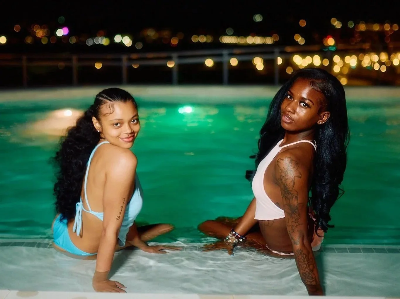 Black women sitting rooftop poolside