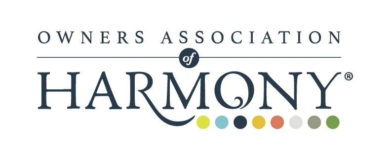 Logo for Owners Association of Harmony with the words in black font and small colored dots below.